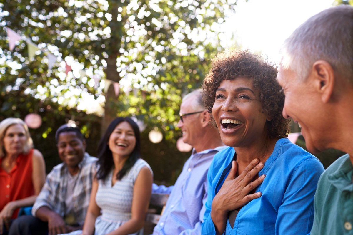 Group,Of,Mature,Friends,Socializing,In,Backyard,Together